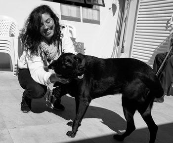 Smiling woman playing with dog