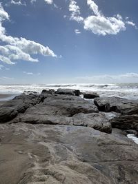 Rocks on beach against sky