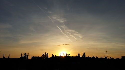 Silhouette cityscape against sky during sunset