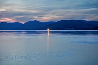 Scenic view of lake against sky at sunset