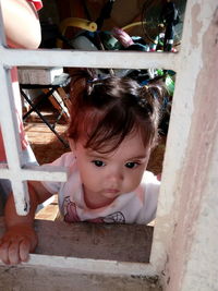 Cute baby girl looking through window