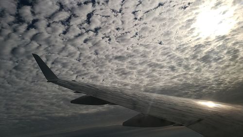 Close-up of airplane wing against sky