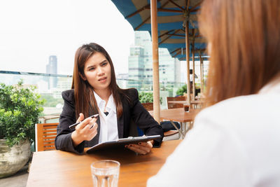Businesswoman discussing with colleague in cafe