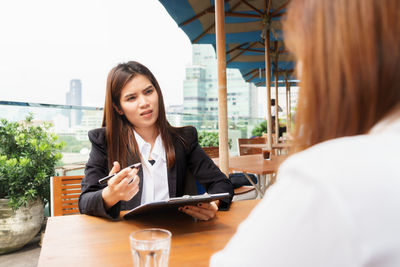 Beautiful young woman sitting on table