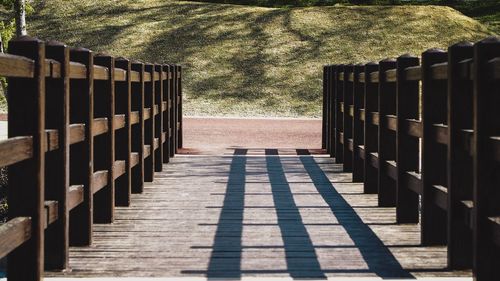 Footpath by railing on sunny day