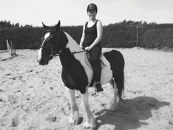 Portrait of woman riding horse at beach