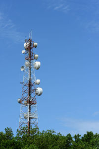 Low angle view of communications tower against blue sky