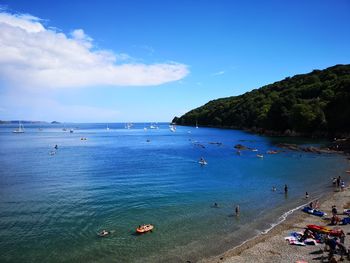 People on beach against blue sky