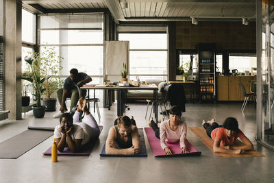 Colleagues lying on exercise mats in office