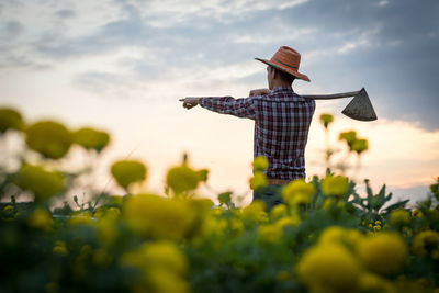 Low angle view of man standing on field against sky
