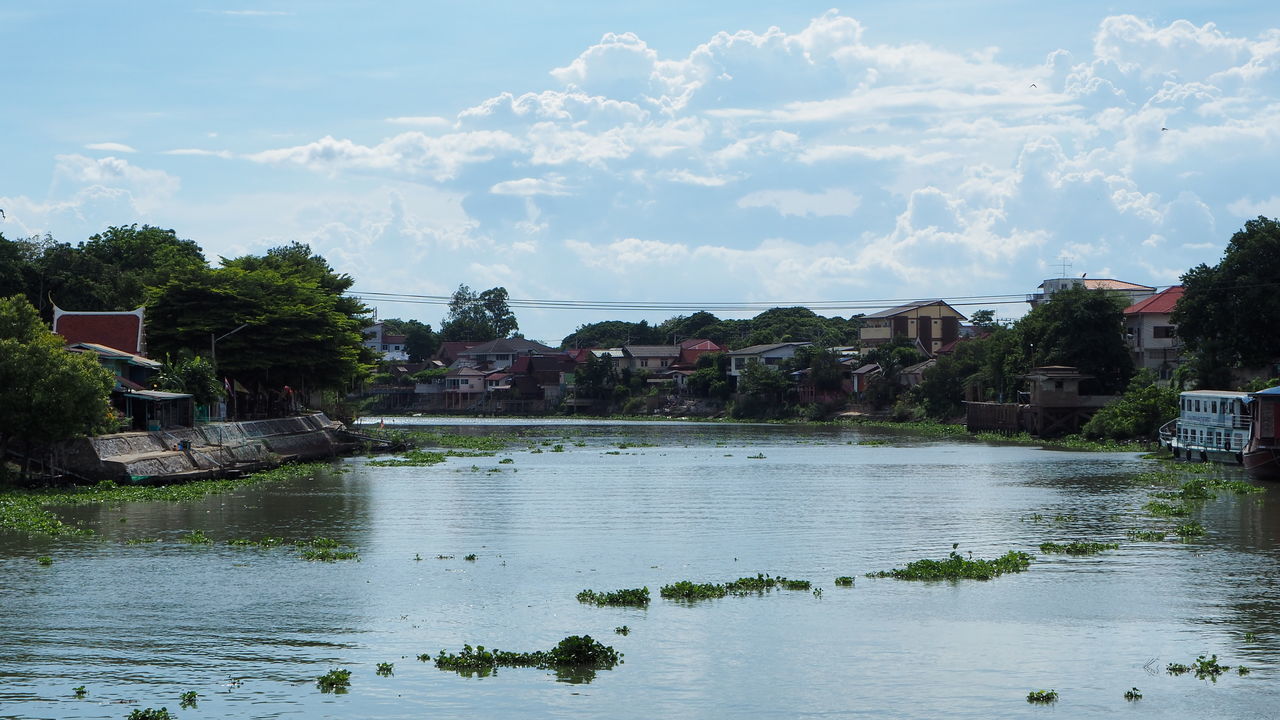 RIVER BY BUILDINGS AGAINST SKY