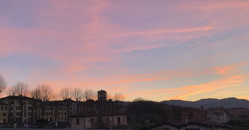 Silhouette buildings against sky at sunset