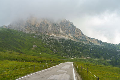 Road amidst green landscape against sky