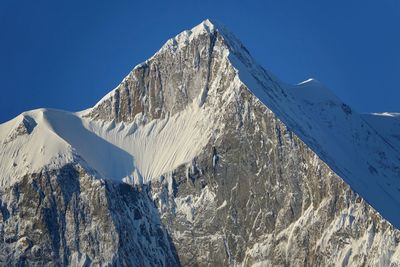 Snowcapped mountain against clear blue sky