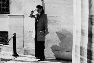 Full length of woman standing against building