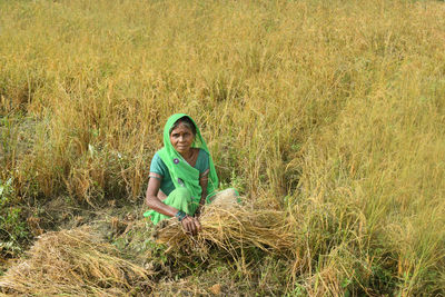 Portrait of smiling young woman harvesting rice paddy 