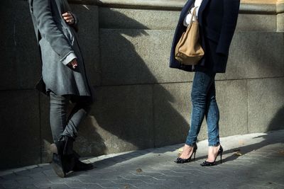 Low section of people standing on sidewalk