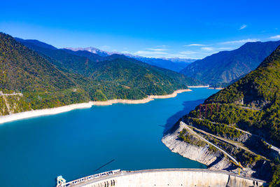 Scenic view of lake and mountains against blue sky