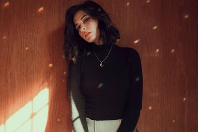 Young woman standing against wall