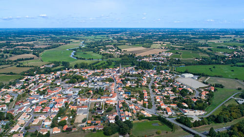 High angle view of town by sea against sky