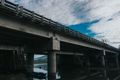 Low angle view of bridge over river against sky