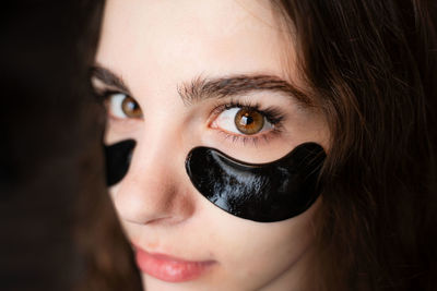 Close-up portrait of woman with beauty product