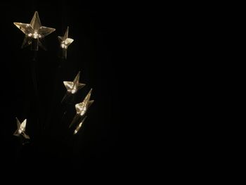 Close-up of illuminated lighting equipment against black background