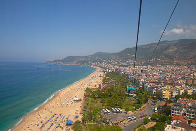 Aerial view of townscape by sea against sky