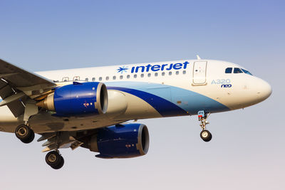 Low angle view of airplane against clear blue sky