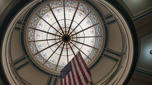 Low angle view of american flag below cupola in courtroom