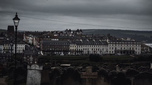 Buildings in city against cloudy sky