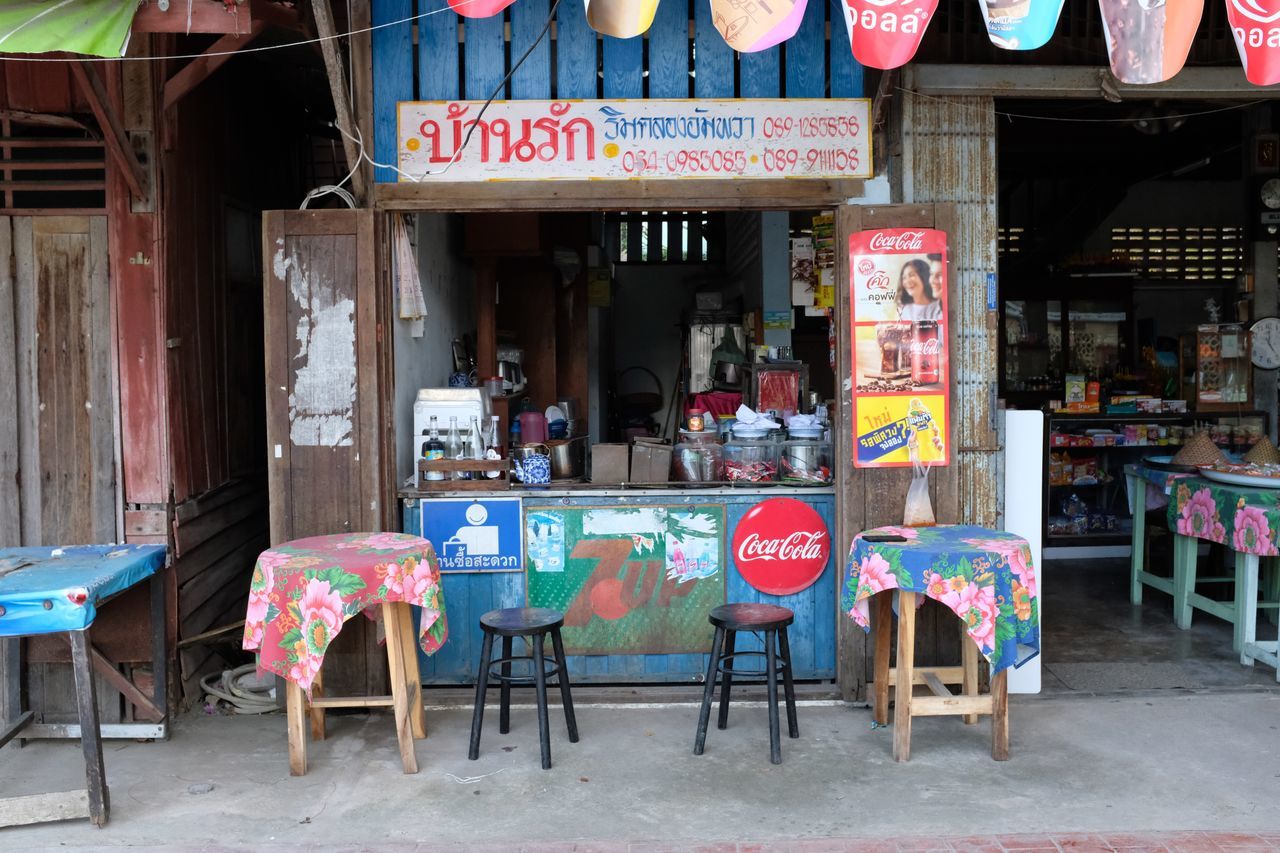 text, communication, architecture, built structure, western script, table, building exterior, seat, day, food and drink, sign, chair, restaurant, city, business, no people, store, outdoors, non-western script, empty