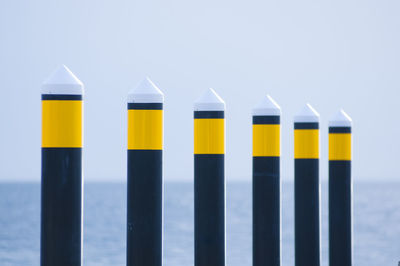 Close-up of yellow metallic structure in sea against sky