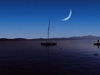 Scenic view of lake against sky at night