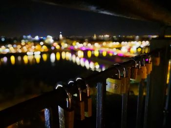 Close-up of illuminated lighting equipment on railing at night