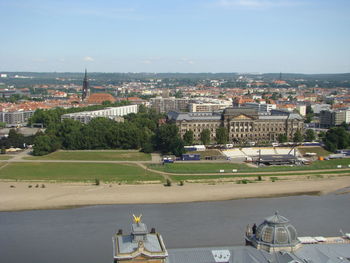 High angle view of townscape by river against buildings in city