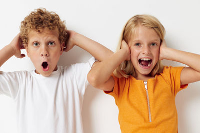 Portrait of smiling sibling against white background