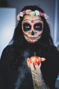 Close-up portrait of woman holding mask