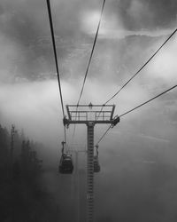 Low angle view of overhead cable car against sky