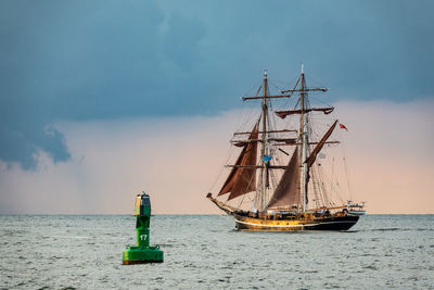 Sailboat sailing on sea against sky