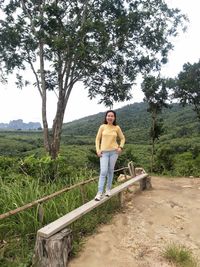 Full length of man standing by railing against trees