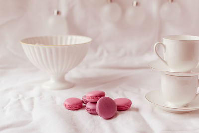 Close-up of pink macaroons with coffee on table