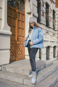 Full length of young man standing against building