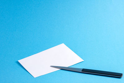 High angle view of white paper against blue background