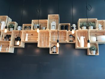 Low angle view of various objects arranged in shelves mounted on wall
