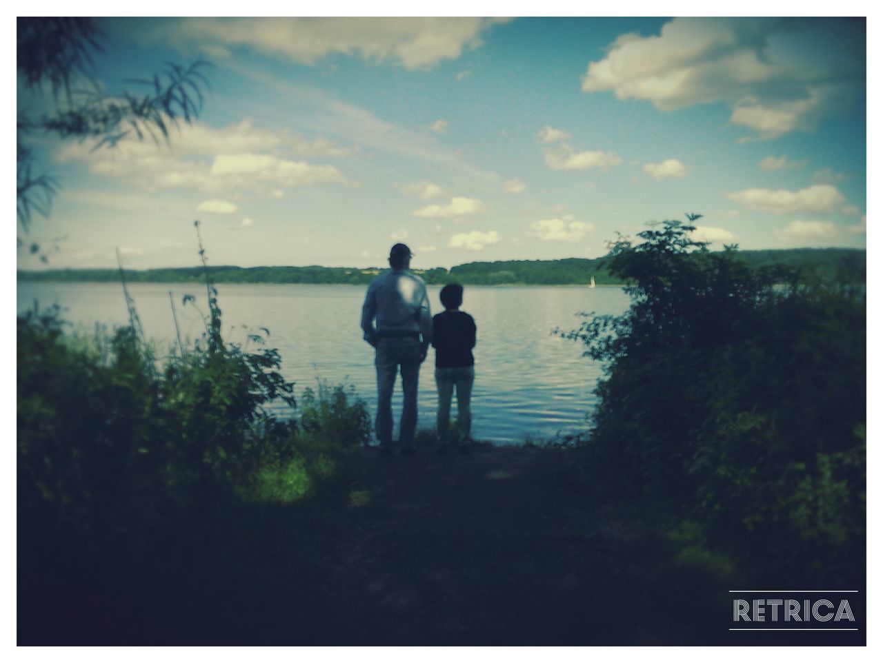 transfer print, water, auto post production filter, lifestyles, reflection, sky, leisure activity, lake, men, tranquility, tree, nature, waterfront, tranquil scene, full length, outdoors, day, river