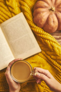 High angle view of person holding coffee cup on table