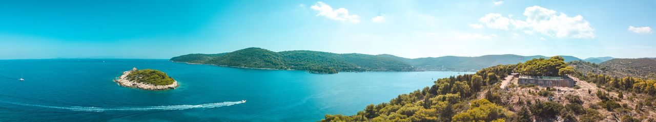 Panoramic view of sea and mountains against sky