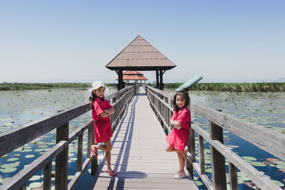 Two cute little girls standing in bridge