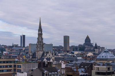 Buildings in city against cloudy sky